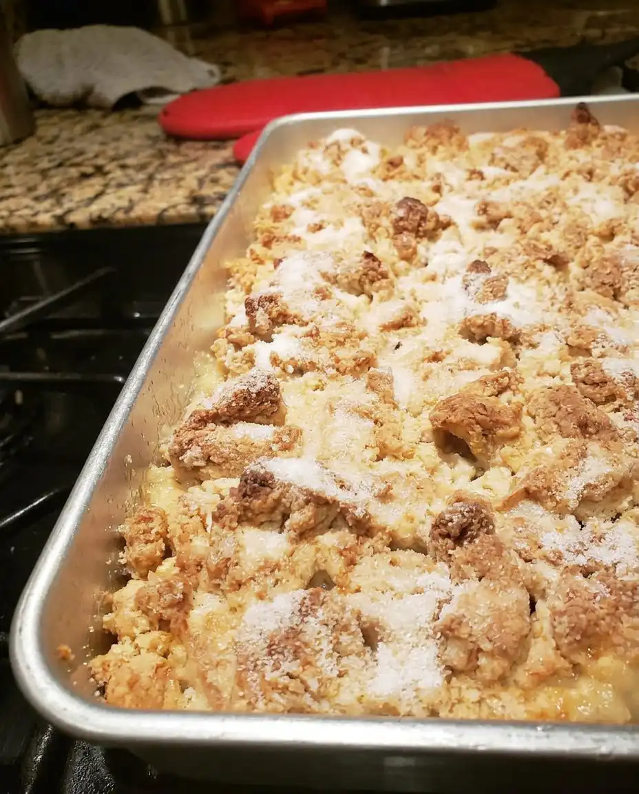 A bowl of warm peach cobbler topped with a melting scoop of vanilla ice cream