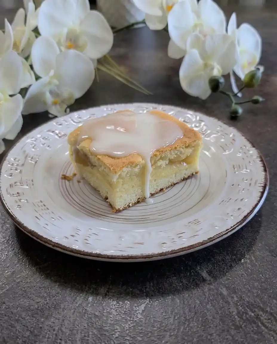 A square Peaches and Cream Bar served next to a cup of tea on a wooden table.