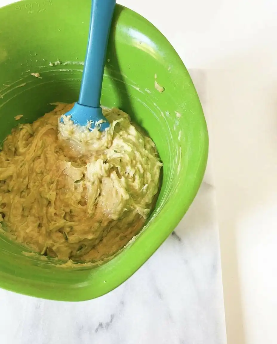 A bowl of freshly grated green zucchini ready to be folded into muffin batter.