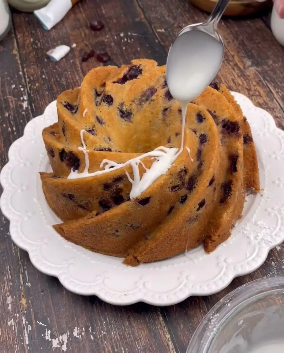 A baker sifting fine cake flour into a bowl to ensure a light and airy cake texture