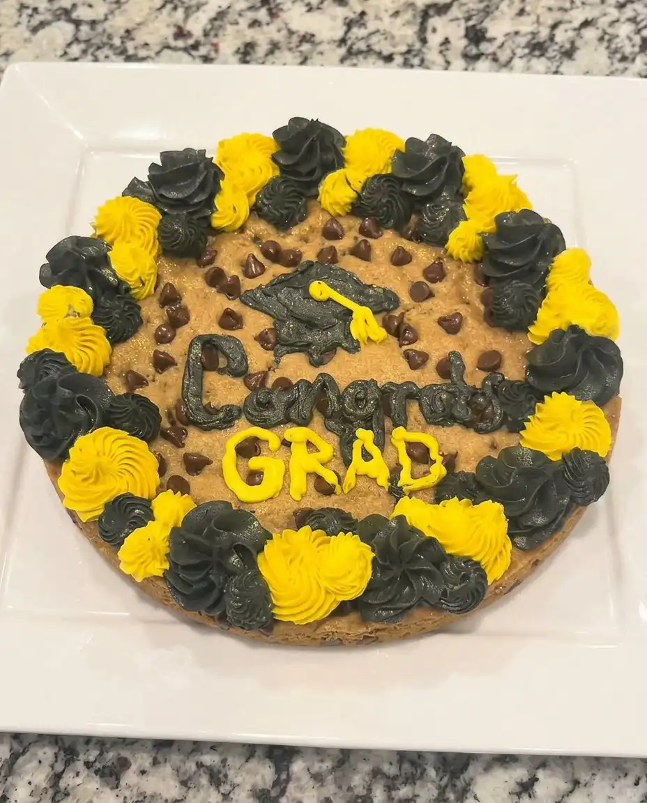 A single slice of chewy cookie cake with frosting on a vintage floral china plate.