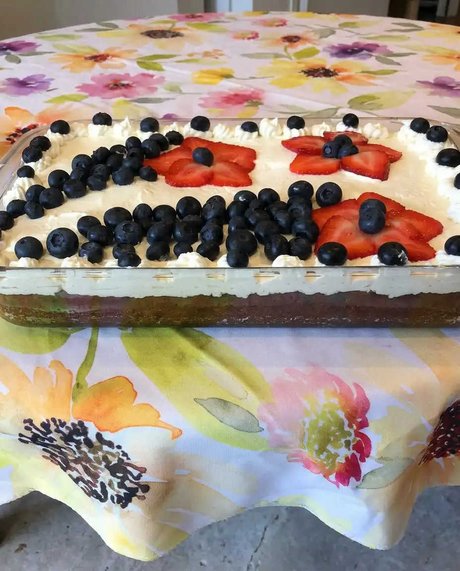 A clean slice of a 4th of July brownie on a white plate showing the dense fudge layer and berry topping