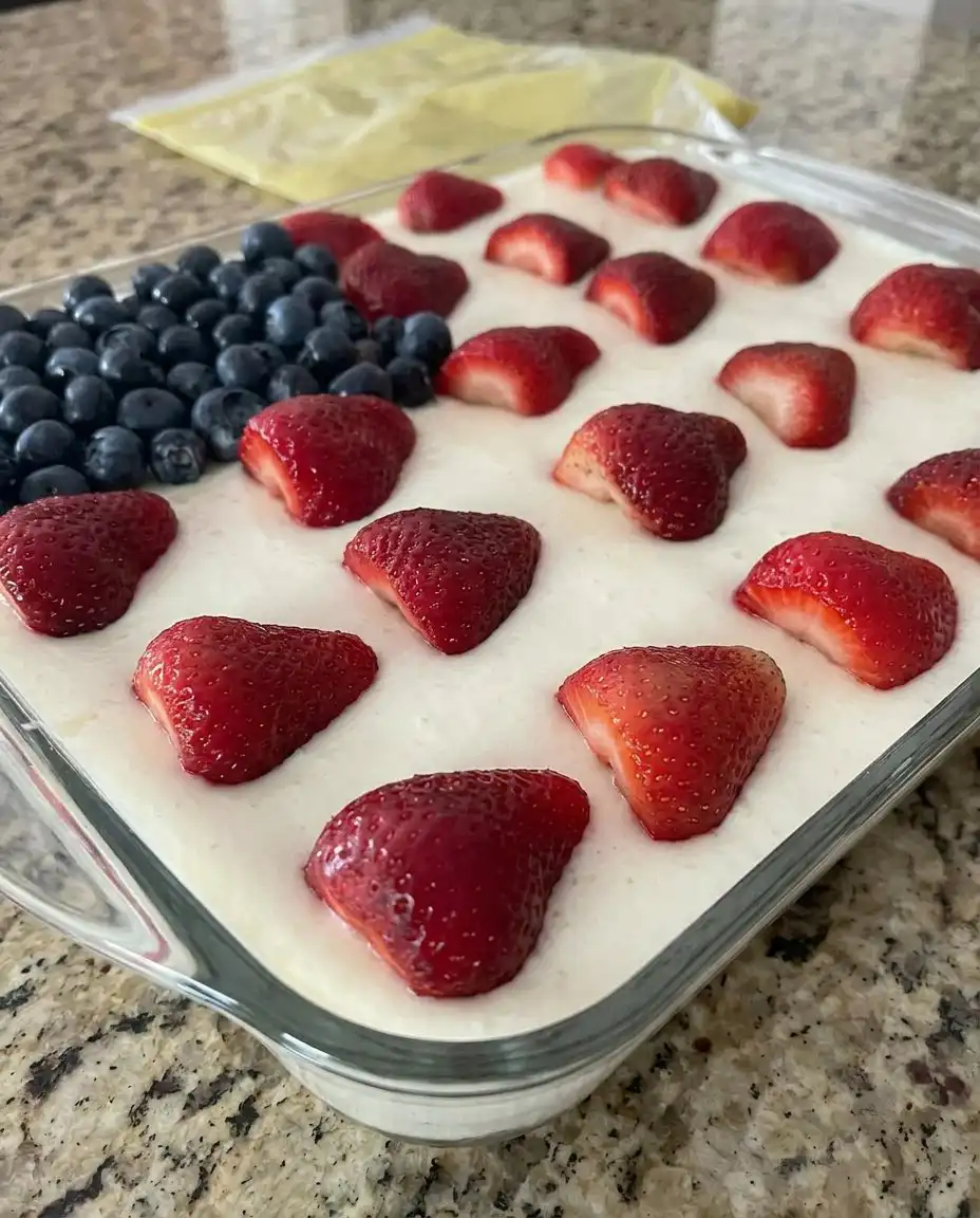 A single square slice of the American flag cake on a white plate, showing the moist red-infused interior.