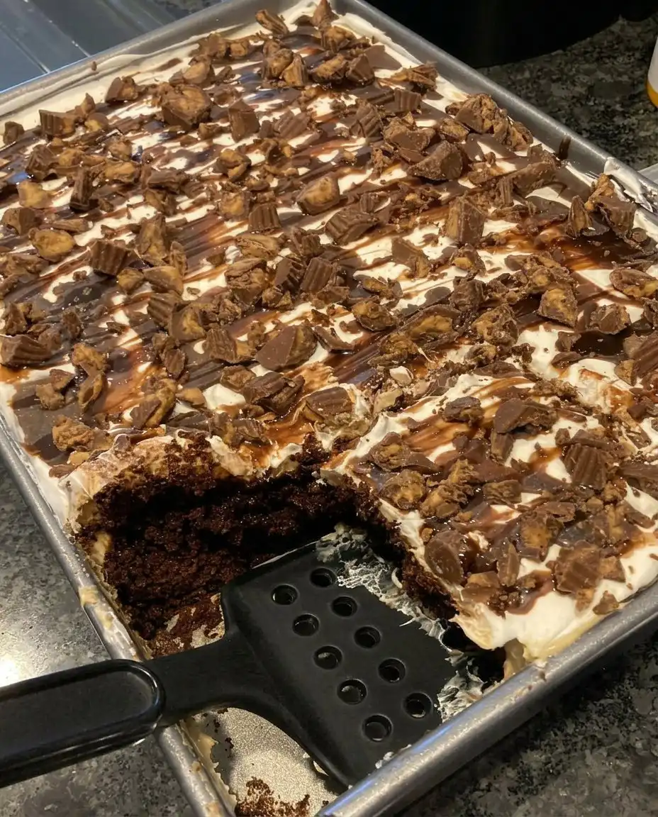 A single slice of Reese's peanut butter cup poke cake showing the internal pudding layers.