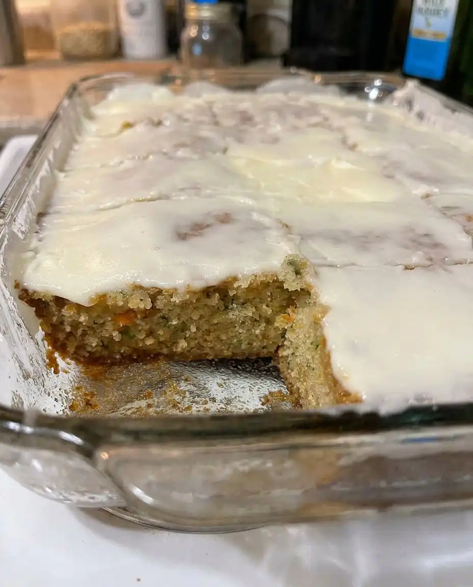A plate of neatly sliced zucchini bars topped with smooth caramel frosting.