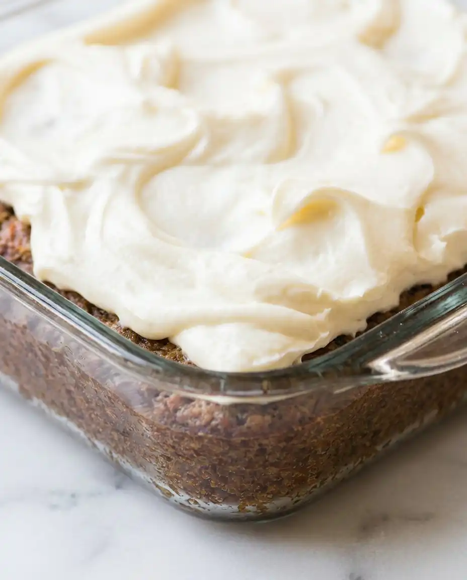 A single square slice of Old-Fashioned Zucchini Cake on a white plate showing the dense spiced interior.