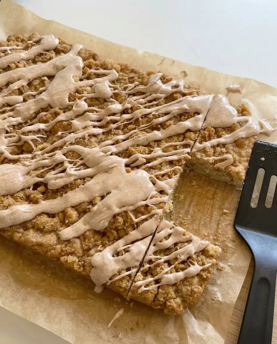 A tray of sliced zucchini crumb cake bars with drizzled icing