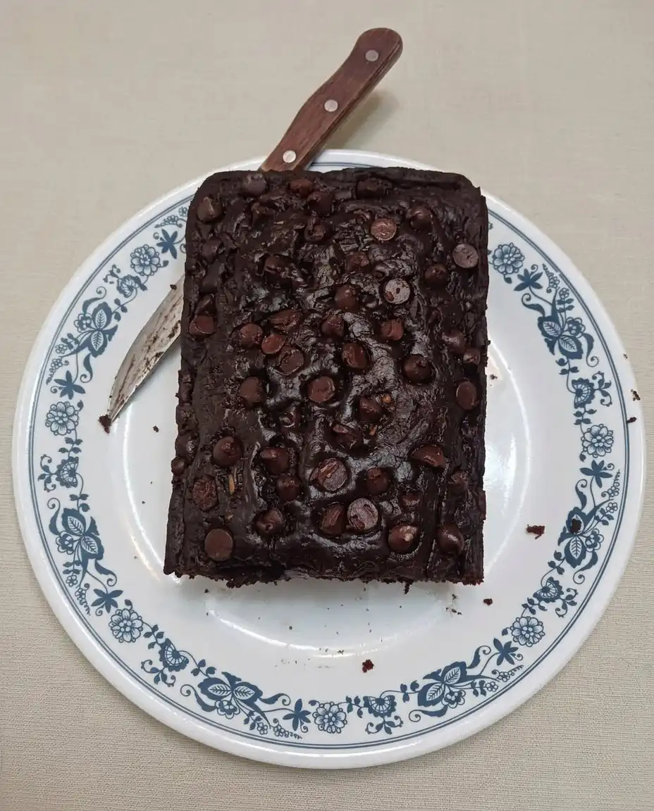 A knife slicing through a moist chocolate zucchini bread