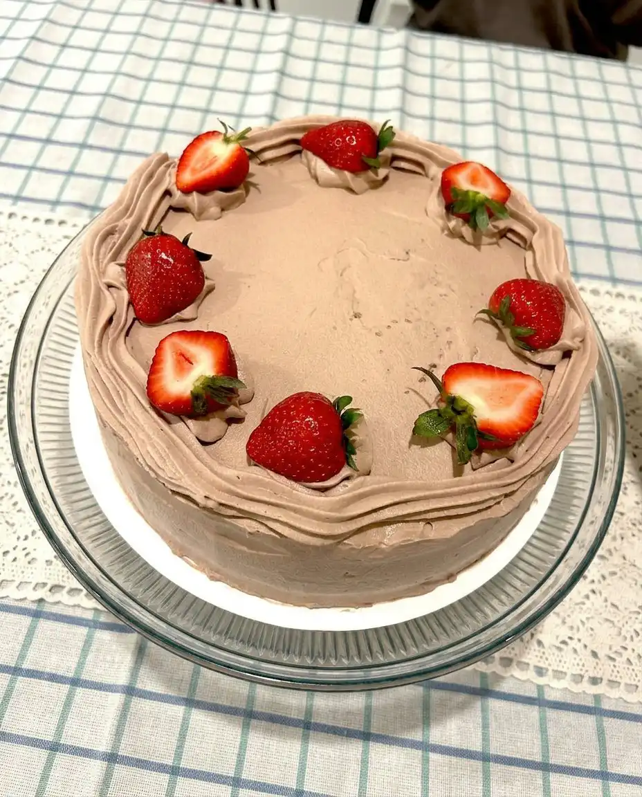 A single slice of strawberry chocolate cake on a plate showing the internal jam layers