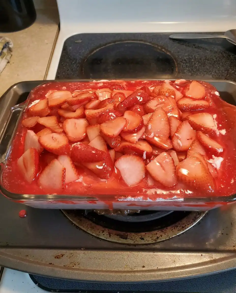 A single slice of Strawberry Heaven served on a white plate with a mint garnish.