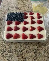 A top-down view of the Strawberry Jello American Flag Cake with vibrant blueberry stars and strawberry stripes.