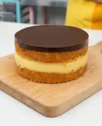 A perfectly assembled Two-Layer Boston Cream Cake with thick pastry cream and chocolate glaze.