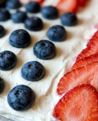 A beautifully decorated gluten-free flag cake sitting on a vintage floral plate outdoors