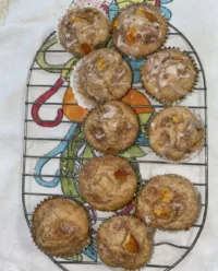 Homemade peach cobbler muffins with streusel topping on a white lace tablecloth