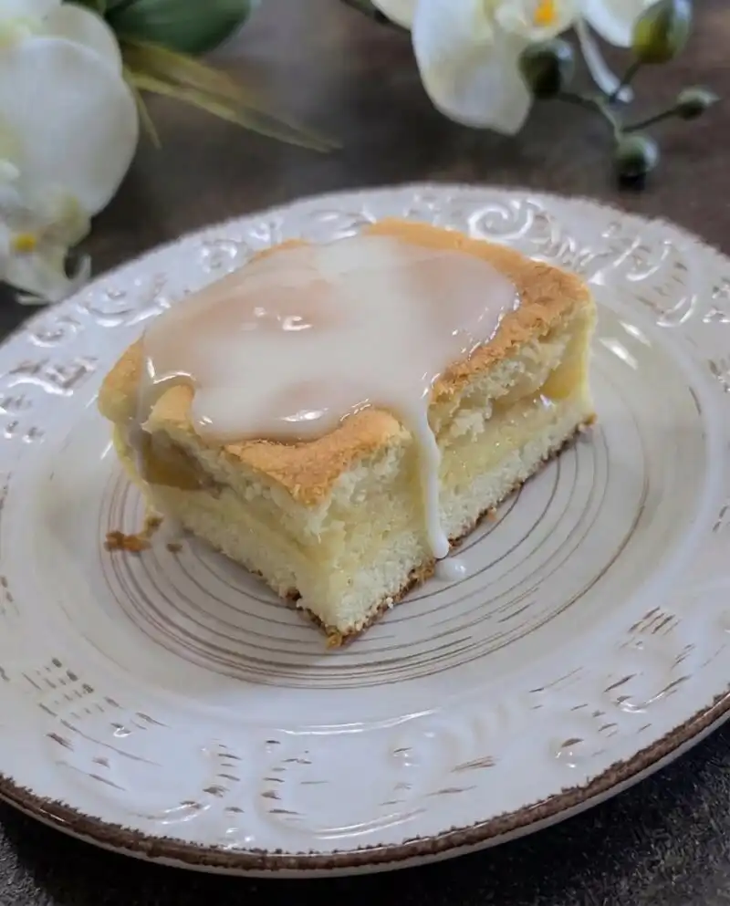 Home - Cake Half - Small Batch Baking & Cupcakes 3 A close up view of golden Peaches and Cream Bars layered with fruit and glaze on a vintage plate.