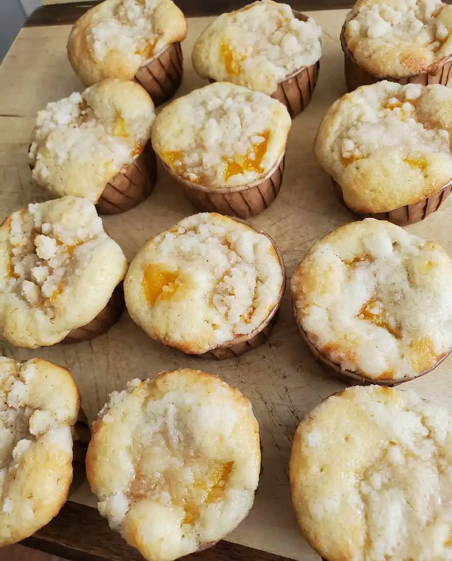 A single peach cobbler muffin split open with butter on a vintage floral china plate