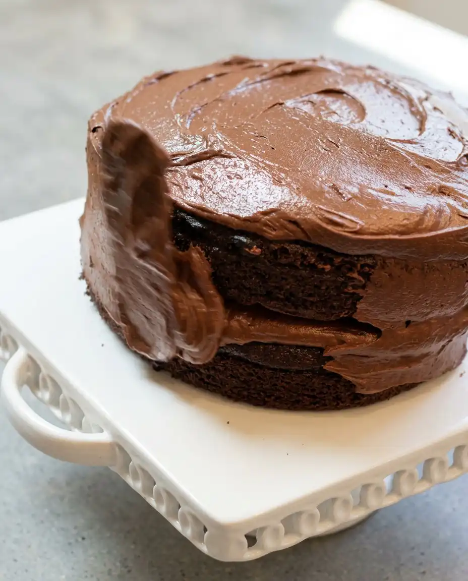 Pouring thin batter into round baking pans for a Hershey's Perfectly Chocolate Cake.
