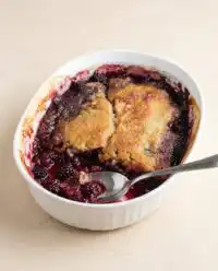 A freshly baked Blackberry Cobbler Dump Cake in a glass baking dish showcasing a golden crust.