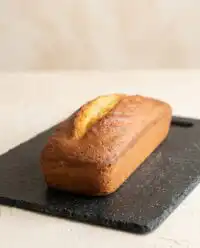 A golden slice of classic Vanilla Pound Cake resting on a vintage floral china plate.