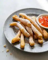 A golden pile of crispy Classic Funnel Cake Fries dusted with white powdered sugar