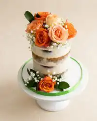 A stunning three tier Naked Cake with Fall Flowers decorated with purple pansies and green mint leaves