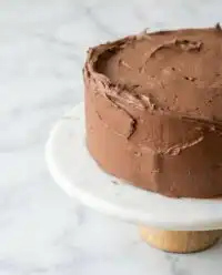 Two cooled layers of One-Bowl Chocolate Zucchini Cake resting on a wire rack before frosting.