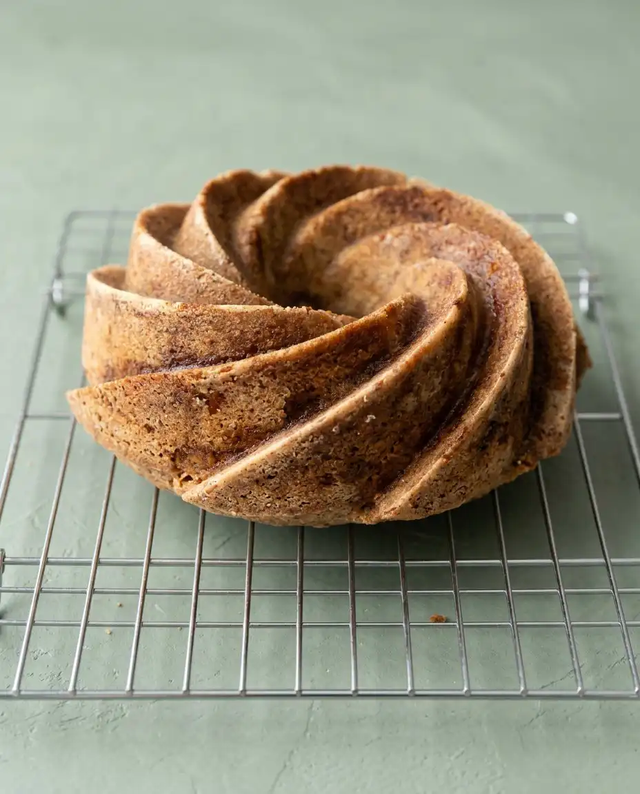 Serving a fresh slice of Spiced Pear Cake on a vintage porcelain plate with whipped cream.