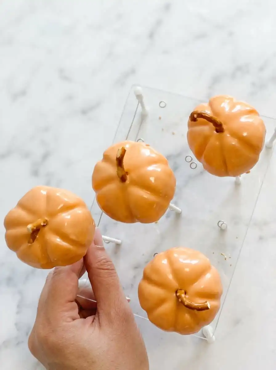 A collection of Classic Pumpkin Cake Pops displayed beautifully on an antique blue transferware platter.