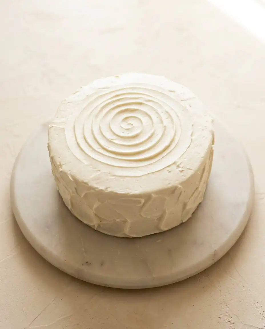 A beautiful slice of red velvet layer cake served on a vintage floral plate with a silver fork