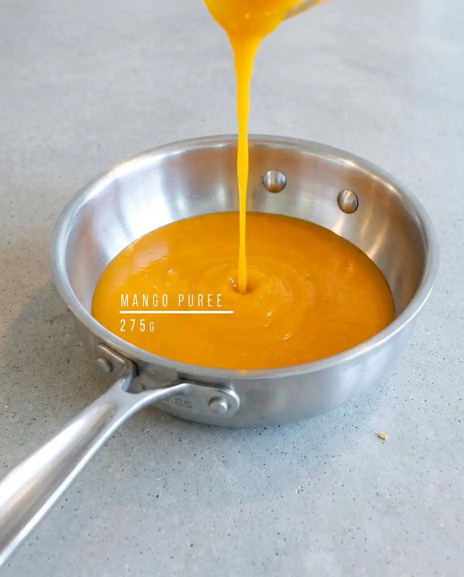 Slicing a perfect piece of Classic Mango Mousse Cake to show the distinct sponge and mousse layers