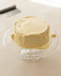 A beautiful two-layer peanut butter cake frosted with creamy peanut butter frosting on a vintage platter