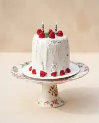 A beautifully chilled Watermelon Cake with Whipped Coconut Frosting decorated with fresh summer berries.